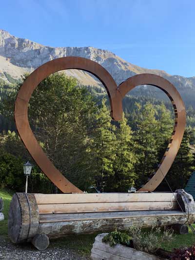 Großes Herz vorm Alpengasthof Scheikl mit Massiv der Hohen Veitsch im Hintergrund